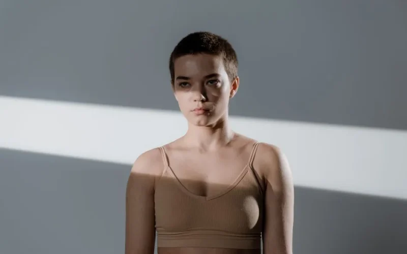 Portrait of a young woman with short hair in soft studio lighting.