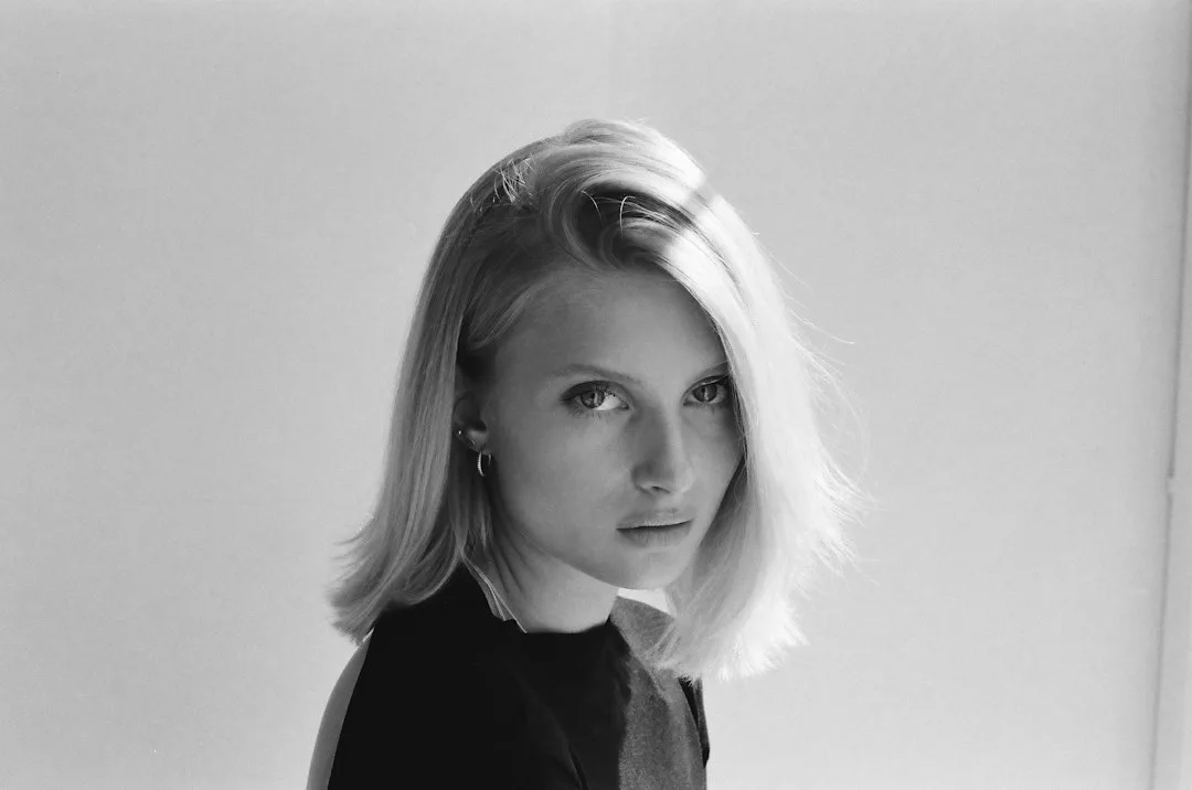 Young blonde woman with short hair looking intently.