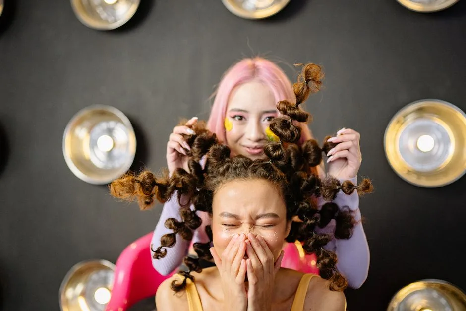 Two young women with creative hairstyles having fun in a stylish studio setting.