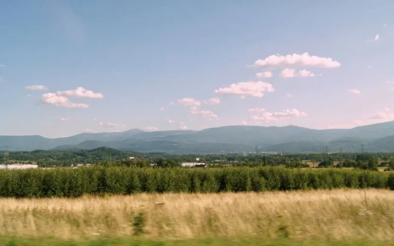 Picturesque landscape of mountains and fields under a blue sky in Poland.