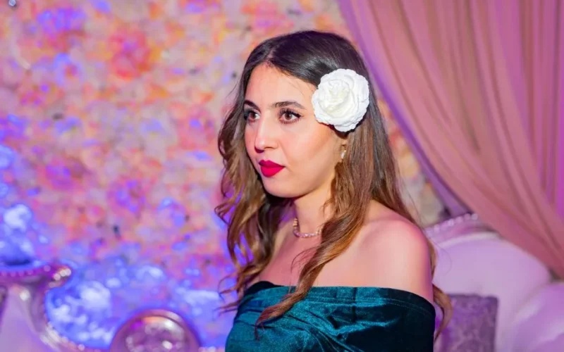Beautiful portrait of an elegant woman with a flower accessory in a stylish indoor setting.
