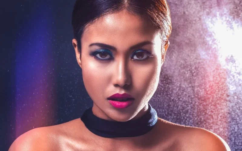 Captivating portrait of a woman with striking makeup and bold lighting.