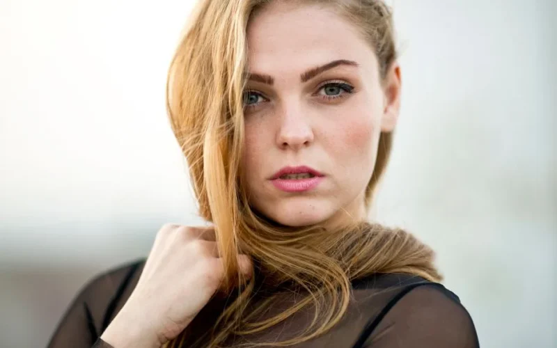 Close-up portrait of a beautiful young woman with blonde hair and striking eyes.