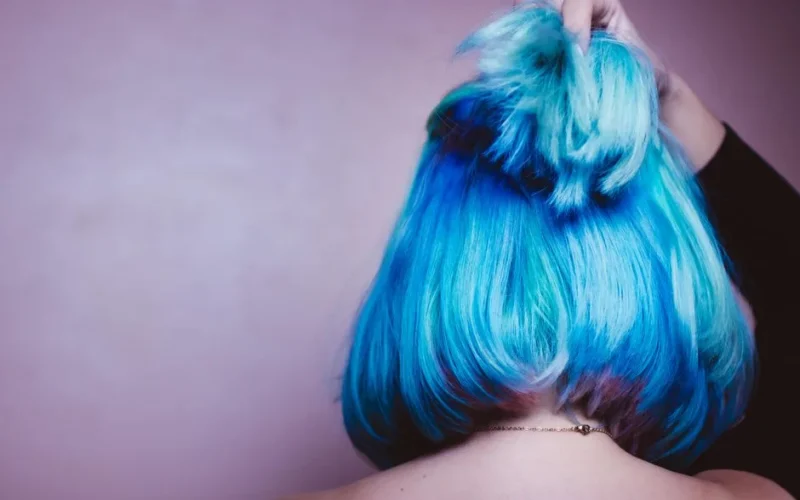 A striking image showcasing vibrant blue hair styled in an elegant updo against a soft backdrop.