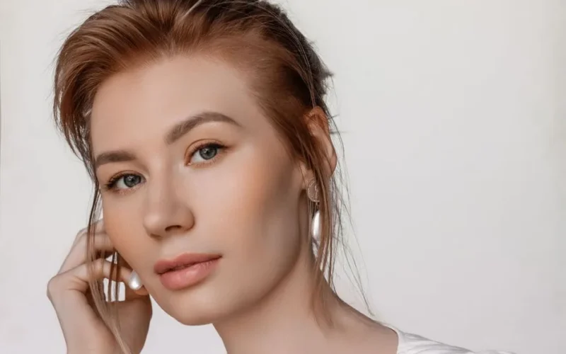 Elegant studio portrait of a young woman with clean makeup and earrings, taken in Moscow.