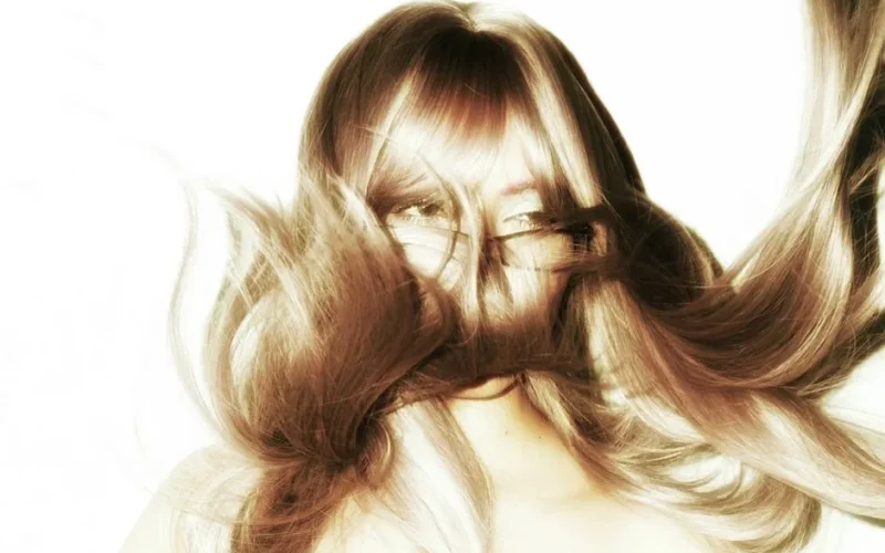 Artistic portrait capturing flowing hair with face obscured, creating a dynamic and mysterious visual.