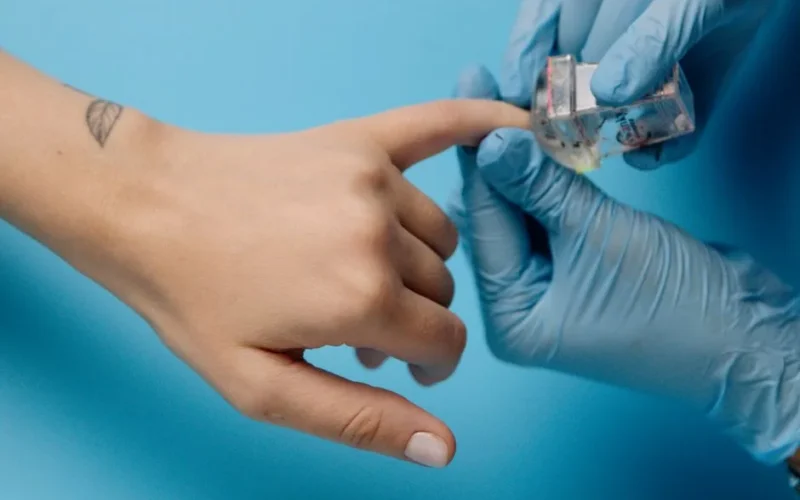 Close-up of a meticulous manicure with blue latex gloves applying nail polish.