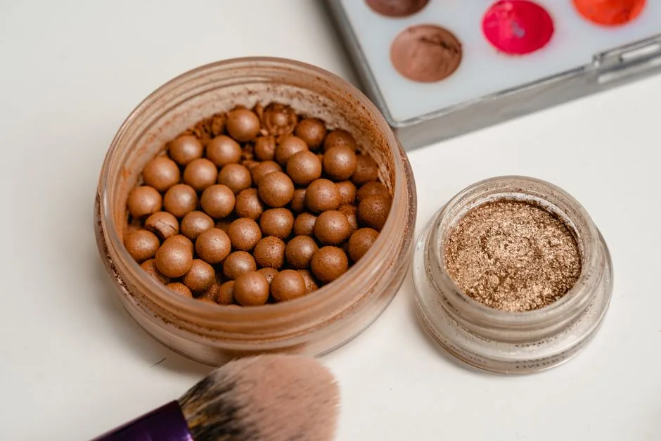 Macro shot of cosmetic powder pearls and brushes with colorful palette.